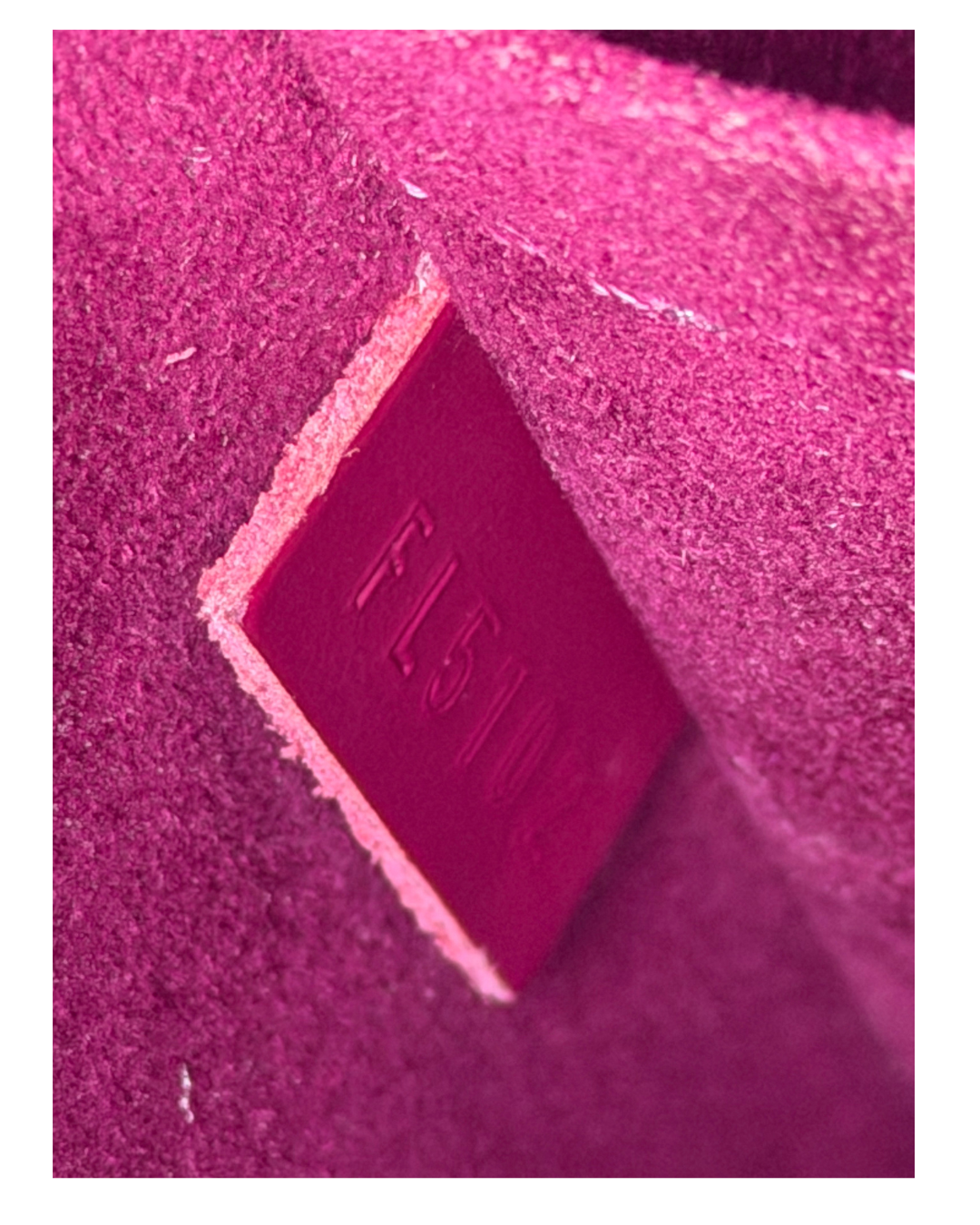 A close-up of a textured magenta pink material with a small embossed diamond-shaped label reading 'FL5102'.