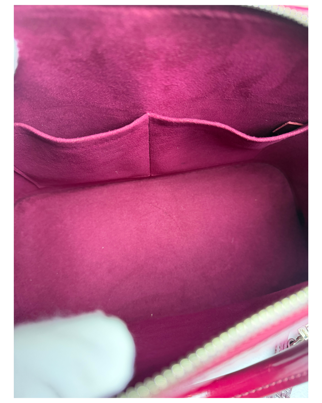 Close-up of the interior lining of a pink bag, showing a plush velvet-like fabric in a magenta-pink color with a light-colored zipper trim.